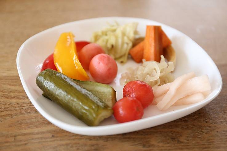 白いお皿にきゅうり、ラディッシュ、にんじん、パプリカ、トマトのリンゴ酢を使ったピクルスが盛られている