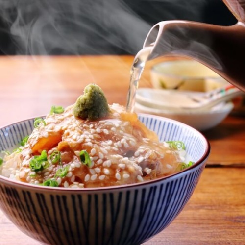 お茶碗に盛られた鯛茶漬けにだしをかけている