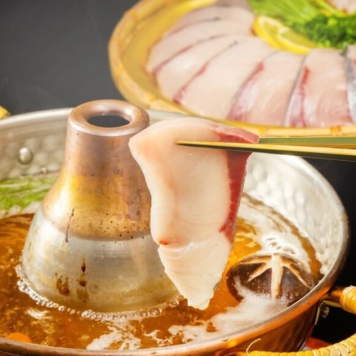 ぶりのしゃぶしゃぶ鍋。箸で薄切りのぶりがつままれている