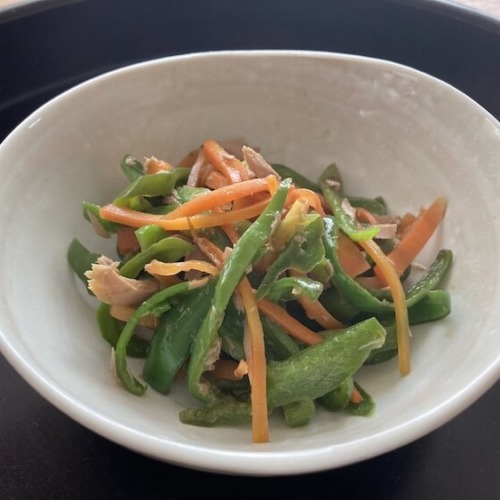 白い小鉢に千切りになったピーマンとにんじん、ツナのおかずが入ってる