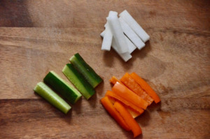 きゅうりと大根とパプリカがスティック状に切られて、まな板に乗っている