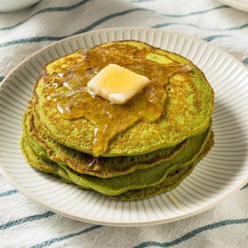 虎杖粉末入りのパンケーキが3枚重なっている。上にはバターと蜂蜜がかかっている。